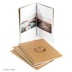 an open photo album with four photos on the cover and two folded pages in front