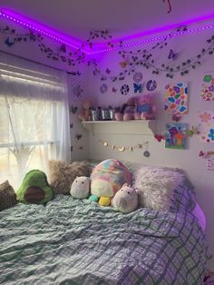 a bedroom with purple lights and stuffed animals on the bed