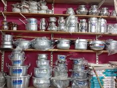 many pots and pans are stacked on shelves