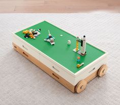 a toy table with legos on it sitting on top of a carpeted floor