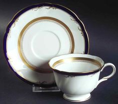 two cups and saucers with gold trim on them