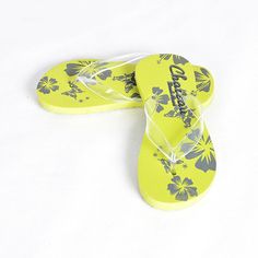 two yellow flip flops with flowers on them sitting on a white surface next to each other