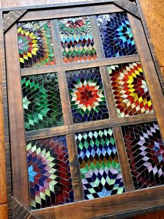 a stained glass window sitting on top of a wooden floor