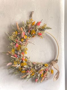 a wreath with flowers hanging on the wall