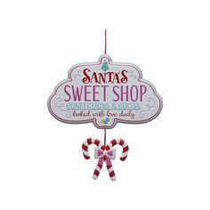 a sign that says santa's sweet shop with candy canes hanging from it