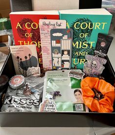 an open box filled with assorted books on top of a table next to other items