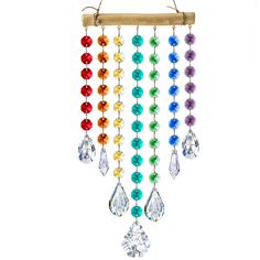 a colorful wind chime hanging from a wooden stick with beads and crystals on it