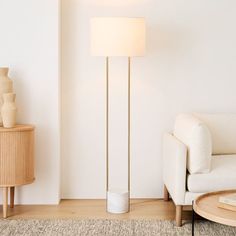 a living room with a white couch and floor lamp