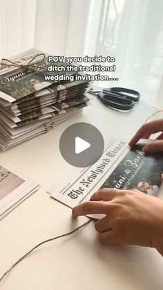 a person that is cutting some paper on a table