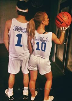 two people in basketball uniforms are holding a ball and looking at each other while standing next to an open door