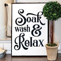 a sign that says soak, wash & relax next to a potted plant