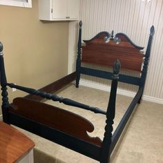 a wooden bed frame in a room with beige walls