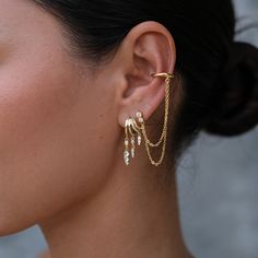 Unleash your inner edge with the Siren Double Chain in Gold Plated. This striking accessory features a chunky, irregular cuff designed to be worn on the lower helix, adding a bold touch to your look without the need for multiple piercings. The cuff is connected by two delicate chains that drape elegantly, creating a dramatic layered effect that instantly elevates your style. With only one piercing needed, the Siren Double Chain Cuff offers a versatile and statement-making addition to any ear sta Double Helix Piercings, Earring Cuff Chain, Helix Jewelry, Cuff Earring, Multiple Piercings, The Siren, September Birthstone Jewelry, August Birthstone Jewelry, Ear Stack