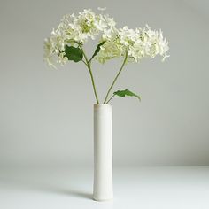 a white vase filled with flowers on top of a table