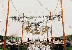 the inside of a tent with tables and chairs set up for an outdoor wedding reception