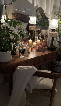 a wooden table topped with lots of plants and candles next to a mirror on top of a wall