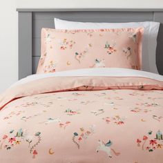 a bed with a pink comforter and pillows