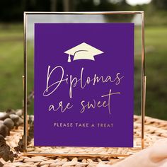 a purple sign that says diplomas are sweet please take a treat with a graduation cap on it