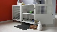 a white cabinet sitting on top of a floor next to a black rug and a stuffed animal