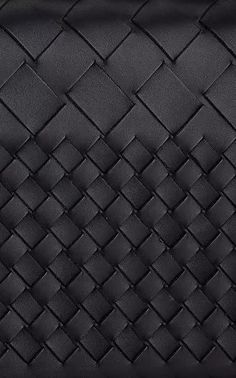 a black leather purse with an intricate weave pattern