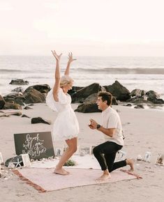 a man and woman doing yoga on the beach