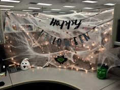 an office cubicle decorated for halloween with spider webs and lights on the wall