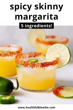 two margaritas with lime and pepper on the rim, surrounded by sliced jalapenos