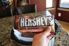 hershey's chocolate bar being held up in front of a countertop top