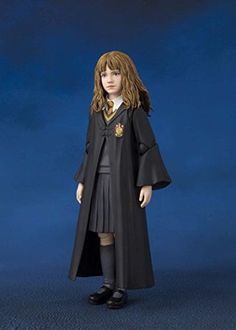 the doll is wearing a long black coat and skirt with a crest on it's lap