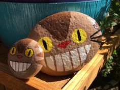 two painted rocks sitting on top of a wooden table