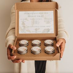 a woman holding a box with candles in it that reads, home - made collective holiday flight