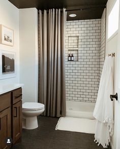 a white toilet sitting next to a bath tub in a bathroom under a shower curtain