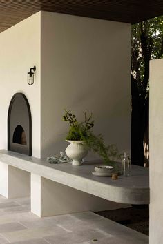 a table with a potted plant sitting on top of it next to a fireplace