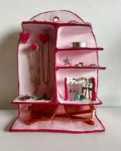 an open pink purse with jewelry on it