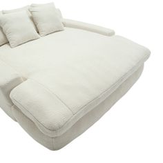 a large white couch with pillows on it's back and side ends facing each other