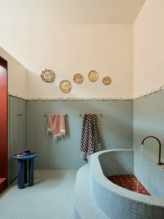 a bath room with a large tub and tiled walls