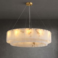 a chandelier hanging from the ceiling in a room with grey walls and flooring