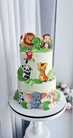 a three tiered cake with animals on it