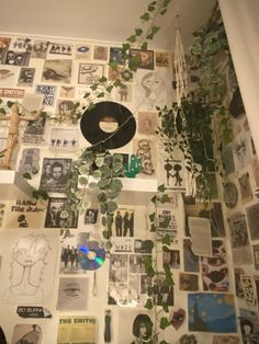 the wall is covered with many pictures and plants