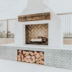 an outdoor fireplace with firewood stacked in it