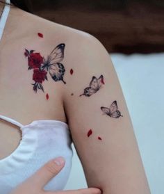 a woman's shoulder with three butterflies and roses on her left arm, the other half is red