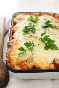 a casserole dish with cheese and parsley