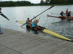 some people are rowing on the water and one is holding a oar with both hands