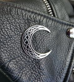 a black leather purse with a crescent design on it