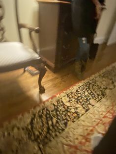 a blurry photo of a person standing in front of a bed with a wooden headboard and foot board