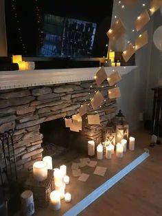 candles are lit in front of a fireplace with notes taped to it and hanging from the mantle