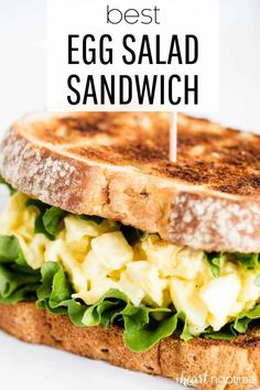 an egg salad sandwich with lettuce and cheese on toasted bread is shown