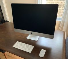 a computer monitor sitting on top of a wooden desk next to a keyboard and mouse