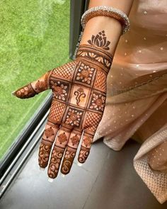 a woman's hand with henna tattoos on it