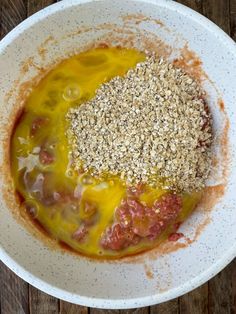 a white bowl filled with food on top of a wooden table